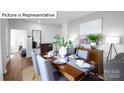 Formal dining room with wood table, gray chairs, and large art piece at 536 Zermatt Ct, Monroe, NC 28112