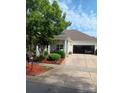 House front featuring a two-car garage and manicured landscaping at 7007 Tanners Creek Dr, Huntersville, NC 28078