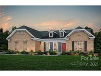 Brick home with a red door and landscaped lawn at 12611 Messenger Row # 455, Huntersville, NC 28078