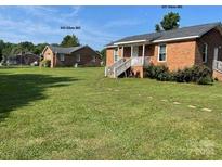 Two brick houses side-by-side with yards and ample parking at 835 & 837 Sikes Mill Rd, Monroe, NC 28110