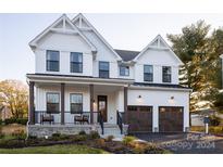 Two story farmhouse style home with dark brown garage doors at 11330 James Coy Rd # Covington, Davidson, NC 28036