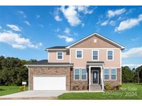 Two-story house with stone and vinyl siding, a white garage door and landscaping at 1030 Heath Helms Rd, Monroe, NC 28110