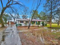 Newly renovated ranch home with white exterior and blue door at 533 Amon Ln, Pineville, NC 28134