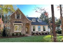 Stone and shingle exterior of charming house with manicured lawn at 208 Bubbling Well Rd, Matthews, NC 28105