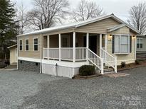 Tan single-wide manufactured home with covered porch at 104 Hummingbird Dr, New London, NC 22812