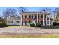 Brick colonial home with a wrap-around porch and landscaped yard at 615 Peach St, Shelby, NC 28150