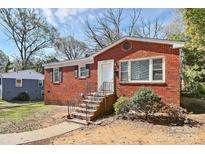 Brick ranch house with a landscaped yard and walkway at 4317 Welling Ave, Charlotte, NC 28208