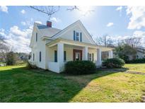 Charming farmhouse with a wraparound porch and mature landscaping at 206 E Allenton St, Mount Gilead, NC 27306
