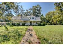 White farmhouse with wrap around porch and large yard at 1813 Saint Marks Church Rd, Crouse, NC 28033