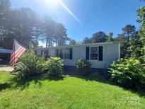 Single-wide mobile home with gray siding and a small deck at 134 Davidson Rd, Clover, SC 29710