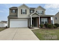 Two-story house with neutral siding, brick accents, and a two-car garage at 1005 Dawn Light Rd, Indian Trail, NC 28079