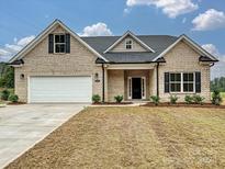 Front view of a beige brick house with a white garage door at 1005 Piper Meadows Dr # 1, Waxhaw, NC 28173