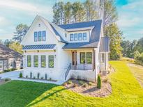 Two-story white farmhouse with gray roof, landscaping, and a paved driveway at 7362 Hemlock Ct, Denver, NC 28037