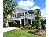 Two-story house with brown siding, white accents, and landscaping at 9839 Quercus Ln, Huntersville, NC 28078