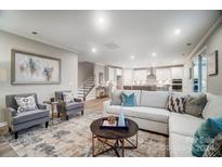 Open living room with L-shaped sofa, coffee table, and modern decor at 9839 Quercus Ln, Huntersville, NC 28078