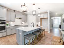 Modern kitchen with gray cabinets, quartz countertops, and a large island at 9835 Quercus Ln, Huntersville, NC 28078