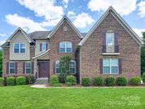 Two-story brick home with landscaping and shutters at 509 Pine Needle Ct, Weddington, NC 28104