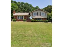 Brick ranch house with large yard and mature trees at 1410 Paddock Cir, Charlotte, NC 28209
