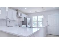 Modern white kitchen with stainless steel appliances and quartz countertops at 12914 Mosby Ln, Charlotte, NC 28273