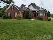 Brick house with a large front yard and mature landscaping at 5916 Meadowmere Dr, Monroe, NC 28110
