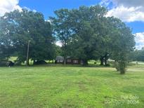 Red house with large trees and green lawn at 2016 N Central Ave, Locust, NC 28097