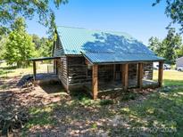 Rustic house with a green metal roof and covered porch at 10910 Archer Rd, Davidson, NC 28036