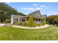 Brick ranch house with a covered porch and landscaped yard at 909 Shinnville Rd, Mooresville, NC 28115