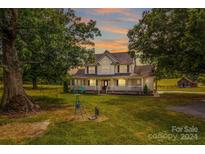 Two story home with wrap around porch and large yard at 11681 Mooresville Rd, Davidson, NC 28036