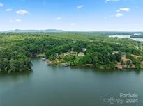 Aerial view of house on lake with a beautiful shoreline and lush trees at 144 Hickory Hollow Ln, Taylorsville, NC 28681