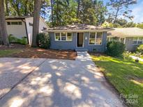 Cute bungalow with gray brick exterior and a walkway at 1913 Herrin Ave, Charlotte, NC 28205