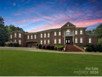 Brick house with large front yard, grand staircase, and gated entry at 9100 Woodhall Lake Dr, Waxhaw, NC 28173
