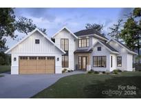 Two-story farmhouse style home with light-colored siding, wood garage door, and landscaping at 337 Tradition Dr, Mount Gilead, NC 27306
