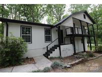 Charming home exterior with black and white accents and a deck at 310 Chaney St, Wingate, NC 28174