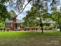 Brick ranch house with mature landscaping and a covered porch at 506 Hearne Farm Rd, Mount Gilead, NC 27306