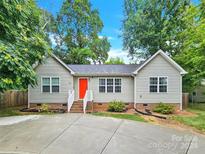 Tan house with red door and driveway at 919 Edgemont Ave, Belmont, NC 28012