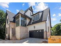 Two-story home with a brick and white exterior, and a two-car garage at 7010 Chateau Bordeaux Ln, Charlotte, NC 28270