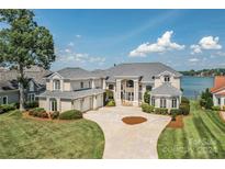 Lakefront home with a large driveway and manicured lawn at 3446 Governors Island Dr, Denver, NC 28037