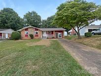 Ranch-style home with red siding and a gravel driveway at 1819 Danbury St, Gastonia, NC 28052