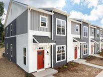 Modern townhome with gray and white siding and a red front door at 1008 Ribbon Ln, Charlotte, NC 28205
