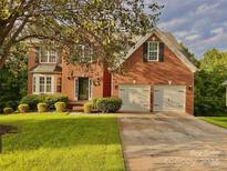 Brick house with two-car garage and well-maintained lawn at 4141 Deerfield Nw Dr, Concord, NC 28027