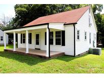 Charming white house with red roof, covered porch, and well-maintained lawn at 518 Williams Ave, Albemarle, NC 28001