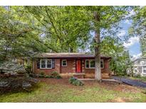 Brick house with red door, landscaping, and large trees at 4120 Winfield Dr, Charlotte, NC 28205