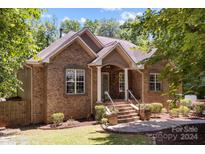 Brick home with a front porch, steps, and landscaping at 7230 Timber Ridge Dr, Mint Hill, NC 28227