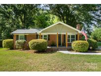 Brick ranch home with covered porch and manicured lawn at 7714 Old Waxhaw Monroe Rd, Waxhaw, NC 28173
