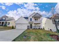 Two-story house with gray stone accents, a two-car garage, and a front porch at 5009 Heathland Dr # 63, Charlotte, NC 28215