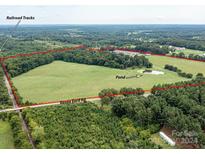 Aerial view of a large lot with pond and railroad tracks at 12136 Renee Ford Rd, Stanfield, NC 28163
