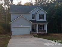Two-story house with gray siding, a white garage door, and landscaping at 265 Prospect Trl, Salisbury, NC 28147