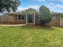 Brick ranch house with covered porch and landscaped yard at 8819 Richardson King Rd, Waxhaw, NC 28173