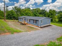 Blue house exterior with a deck and landscaping at 55 Shannon Park Cir, Taylorsville, NC 28681