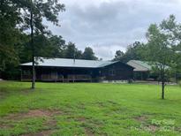 Log cabin home with a wrap-around porch and spacious yard at 2649 Lovin Hill Rd, Candor, NC 27229